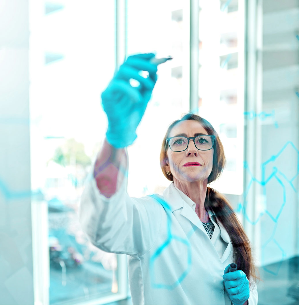 Scientist in a lab coat and gloves drawing chemical structures on glass, representing innovative research and development.