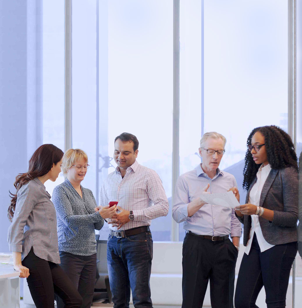 Diverse group of professionals having a discussion in a modern office, representing teamwork and collaboration.