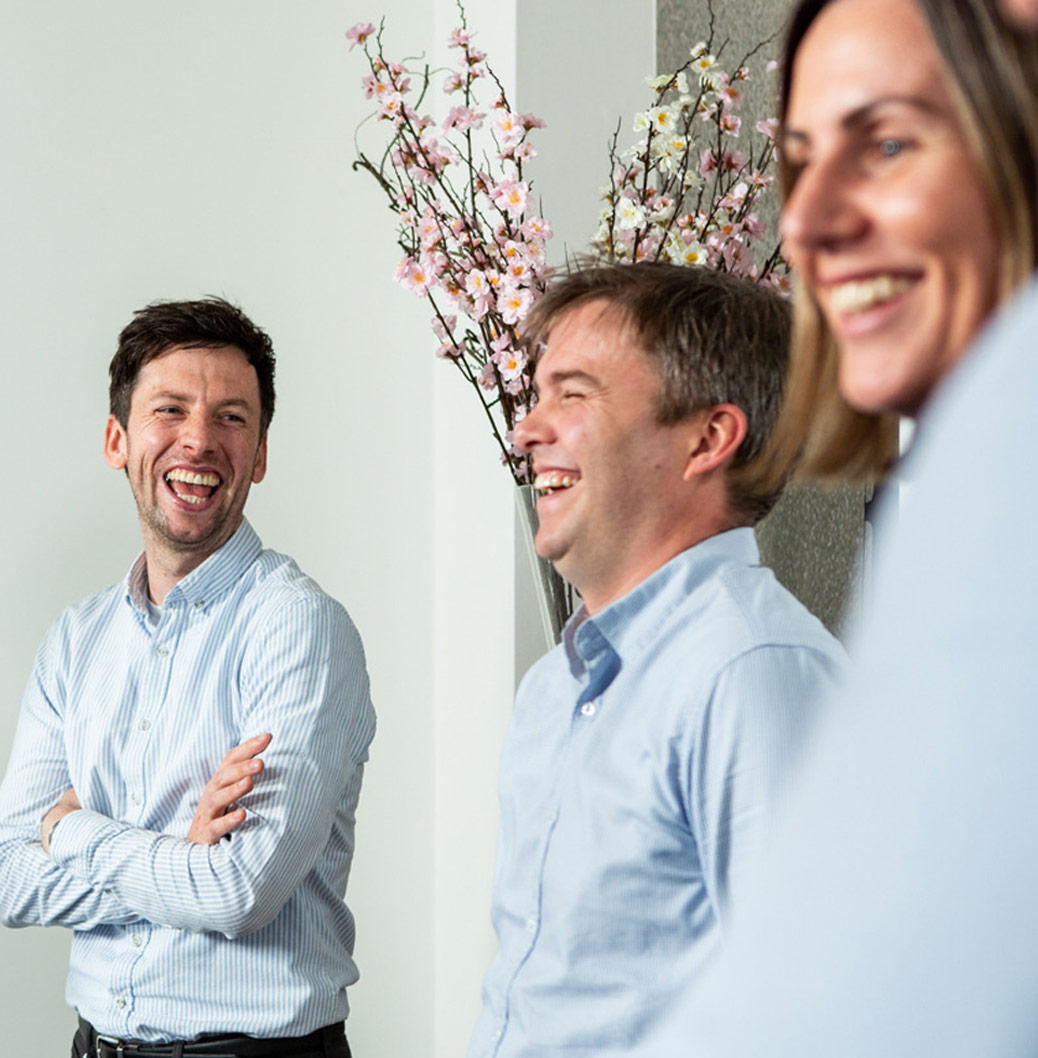 Group of professionals in a cheerful discussion, representing a positive and collaborative work environment.