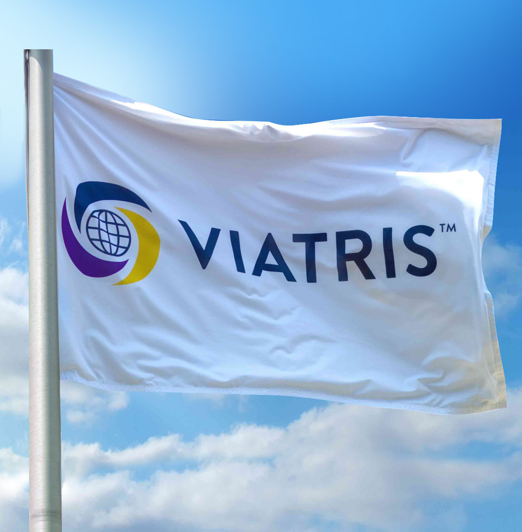 Viatris flag waving against a blue sky with clouds, representing the company's global presence and commitment.